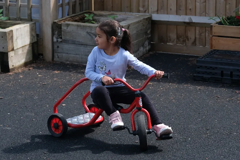 child playing on a tricyle